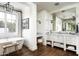 Bright bathroom features a soaking tub by a large window and a vanity with marble countertop at 4716 N Dromedary Rd, Phoenix, AZ 85018