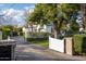 Paver driveway leading to a white home with a gate, brick mailbox, and mature landscaping at 4716 N Dromedary Rd, Phoenix, AZ 85018