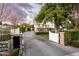 Long driveway leading to a beautiful home, framed by a decorative gate and well-manicured landscaping at 4716 N Dromedary Rd, Phoenix, AZ 85018