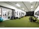 Spacious home gym with a variety of exercise equipment and turf flooring, for a comprehensive fitness experience at 4716 N Dromedary Rd, Phoenix, AZ 85018