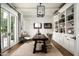 Well-lit home office with custom built-ins, a wooden desk, and French doors leading to the outdoors at 4716 N Dromedary Rd, Phoenix, AZ 85018