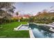 Backyard pool with manicured lawn, privacy hedges, and mountain views at 4716 N Dromedary Rd, Phoenix, AZ 85018