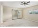 Bright bedroom featuring mirrored closet, ceiling fan, and window at 5013 W Orchid Ln, Glendale, AZ 85302