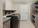 Functional laundry area features storage cabinets, shelving, and appliances at 5013 W Orchid Ln, Glendale, AZ 85302