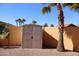 Backyard storage shed with a block wall fence and a lush palm tree nearby at 5622 E Emerald Cir, Mesa, AZ 85206