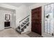 Inviting entryway with a decorative glass sidelight, tile flooring, and staircase leading to the upper level at 5761 E Tierra Buena Ln, Scottsdale, AZ 85254