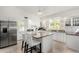 Well-lit kitchen featuring stainless appliances, breakfast bar island, and white cabinetry at 5761 E Tierra Buena Ln, Scottsdale, AZ 85254