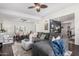 Open concept living room with a large sectional, ceiling fans, hardwood floors, and view into the dining room at 5761 E Tierra Buena Ln, Scottsdale, AZ 85254