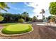 Lush backyard with a putting green, pool, and outdoor dining area for entertaining guests at 5761 E Tierra Buena Ln, Scottsdale, AZ 85254