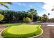 Backyard putting green for recreational enjoyment, surrounded by mature trees and a pool at 5761 E Tierra Buena Ln, Scottsdale, AZ 85254