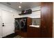 Contemporary laundry room featuring front load washer and dryer with custom cabinetry and ample storage space at 5801 N 22Nd Pl, Phoenix, AZ 85016