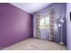 Neutral bedroom with carpeted floor, purple accent wall, and large window at 5808 E Brown Rd # 110, Mesa, AZ 85205