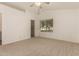 Bright bedroom featuring plush carpet, a ceiling fan, and large window with neighborhood views at 5808 E Brown Rd # 110, Mesa, AZ 85205