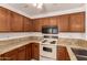 Well-lit kitchen featuring wood cabinets, granite countertops, and modern appliances at 5808 E Brown Rd # 110, Mesa, AZ 85205