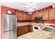 Well-lit kitchen featuring granite countertops, stainless steel appliances, and warm wood cabinets at 5808 E Brown Rd # 110, Mesa, AZ 85205