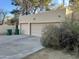 Attached two-car garage with desert landscaping and stucco exterior, complemented by green waste bins at 6242 E Maverick Rd, Paradise Valley, AZ 85253