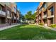 A large, manicured green space between buildings with grass and newly planted trees at 6605 N 93Rd Ave # 1024, Glendale, AZ 85305