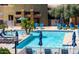 A community pool with blue umbrellas and lounging chairs at 6605 N 93Rd Ave # 1024, Glendale, AZ 85305