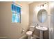 Cozy powder room with white fixtures, a pedestal sink, and ample natural light at 7057 E Diamond St, Scottsdale, AZ 85257