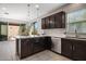 Stylish kitchen featuring dark wood cabinetry, quartz countertops, and modern pendant lighting at 7057 E Diamond St, Scottsdale, AZ 85257