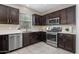 Modern kitchen featuring stainless steel appliances and dark wood cabinetry with white countertops at 7057 E Diamond St, Scottsdale, AZ 85257