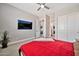 Inviting bedroom featuring neutral walls, a large bed with a red cover, and carpeted floors at 711 W Paso Nuevo Dr, Phoenix, AZ 85086