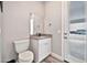 Powder room with vanity and toilet, featuring a window and tiled floor at 711 W Paso Nuevo Dr, Phoenix, AZ 85086