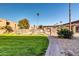 Community pool area featuring desert landscaping, a paved brick path, and mature trees at 7110 E Continental Dr # 1031, Scottsdale, AZ 85257