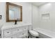 Clean, white bathroom with vanity, classic mirror, bathtub, and tiled walls at 739 E Glade Ave, Mesa, AZ 85204