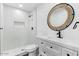 Modern bathroom featuring shower, round mirror, white vanity and tiled walls at 739 E Glade Ave, Mesa, AZ 85204