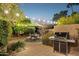 Backyard with a dining table, grill and greenery creating an outdoor haven perfect for entertaining at 8008 N 66Th St, Paradise Valley, AZ 85253