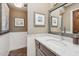 Bathroom featuring a granite vanity top, an undermount sink, decorative mirror and coastal artwork at 8008 N 66Th St, Paradise Valley, AZ 85253