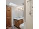 Bathroom featuring a granite-topped vanity, a skylight, a dark wood door, and shower with chrome fixtures at 8008 N 66Th St, Paradise Valley, AZ 85253