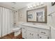 Classic bathroom with a combined tub and shower, white wainscoting, and a granite vanity adding charm at 8008 N 66Th St, Paradise Valley, AZ 85253