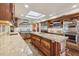 Spacious kitchen featuring a center island with a cooktop, wood cabinets and tile backsplash at 8008 N 66Th St, Paradise Valley, AZ 85253