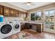 Laundry room with a front load washer/dryer, lots of cabinet storage, and large window overlooking the pool at 8008 N 66Th St, Paradise Valley, AZ 85253