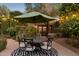 Charming outdoor patio with umbrella, string lights, and a cozy seating area surrounded by lush greenery at 8008 N 66Th St, Paradise Valley, AZ 85253