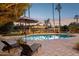 Inviting backyard pool area with lounge chairs, mature landscaping, and a cozy pergola with outdoor seating at 8008 N 66Th St, Paradise Valley, AZ 85253