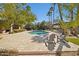 Backyard pool with a tiled surround, a pergola with seating, mature landscaping and tall palm trees at 8008 N 66Th St, Paradise Valley, AZ 85253