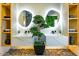 Modern bathroom with double vanity, vessel sinks, decorative stone floor, and unique oval, illuminated mirrors at 815 E County Down Dr, Chandler, AZ 85249