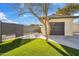 Backyard with a detached garage, iron fence, and newly installed artificial grass at 8215 E Cypress St, Scottsdale, AZ 85257