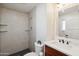 Modern bathroom featuring a tile shower, floating shelves, a vanity with a sink, and a toilet at 8215 E Cypress St, Scottsdale, AZ 85257