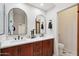 Bathroom with double vanity, marble countertop, modern fixtures, and arched mirrors, offering a luxurious feel at 8215 E Cypress St, Scottsdale, AZ 85257