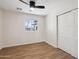 Inviting bedroom featuring wood-look floors, a fan, a window for natural light, and a closet at 8215 E Cypress St, Scottsdale, AZ 85257