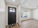 Bright entryway with a black front door, modern light fixture and wood-look floors at 8215 E Cypress St, Scottsdale, AZ 85257