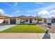 Charming single-story home featuring a well-manicured lawn, attached garage, and inviting front porch at 8215 E Cypress St, Scottsdale, AZ 85257