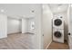 A well-lit laundry room features a stacked washer and dryer, with an adjacent living space visible at 8215 E Cypress St, Scottsdale, AZ 85257