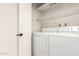 Laundry room features full sized washer and dryer and white wire shelving at 8588 E Indian School Rd # G, Scottsdale, AZ 85251