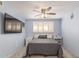 Light-filled bedroom features a cozy bed with a ceiling fan and shuttered windows at 8626 E San Miguel E Ave, Scottsdale, AZ 85250