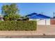 View of a well-maintained home with a manicured hedge, garage, and driveway at 8626 E San Miguel E Ave, Scottsdale, AZ 85250